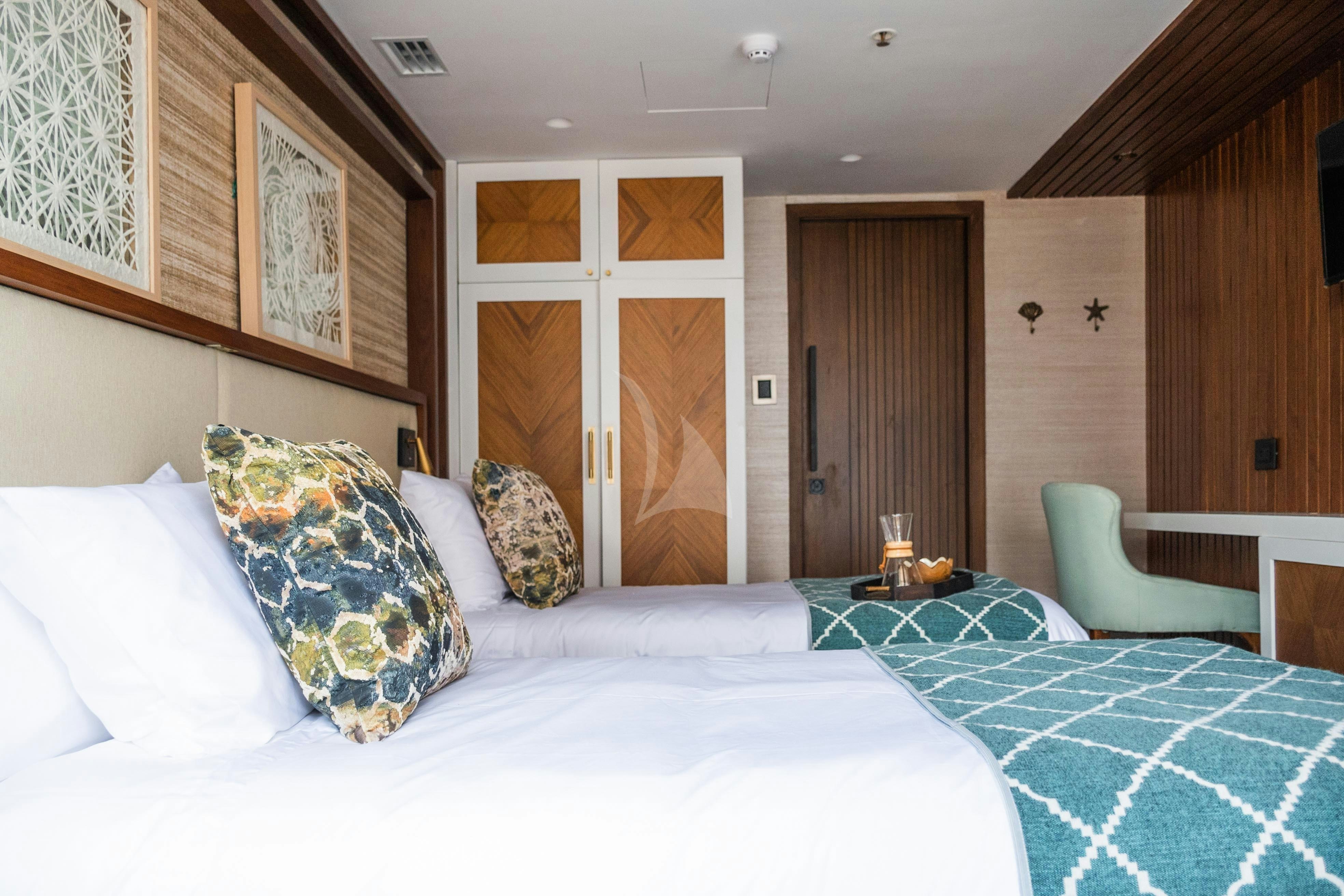 a bedroom with a bed and a chair aboard KONTIKI WAYRA Yacht for Charter