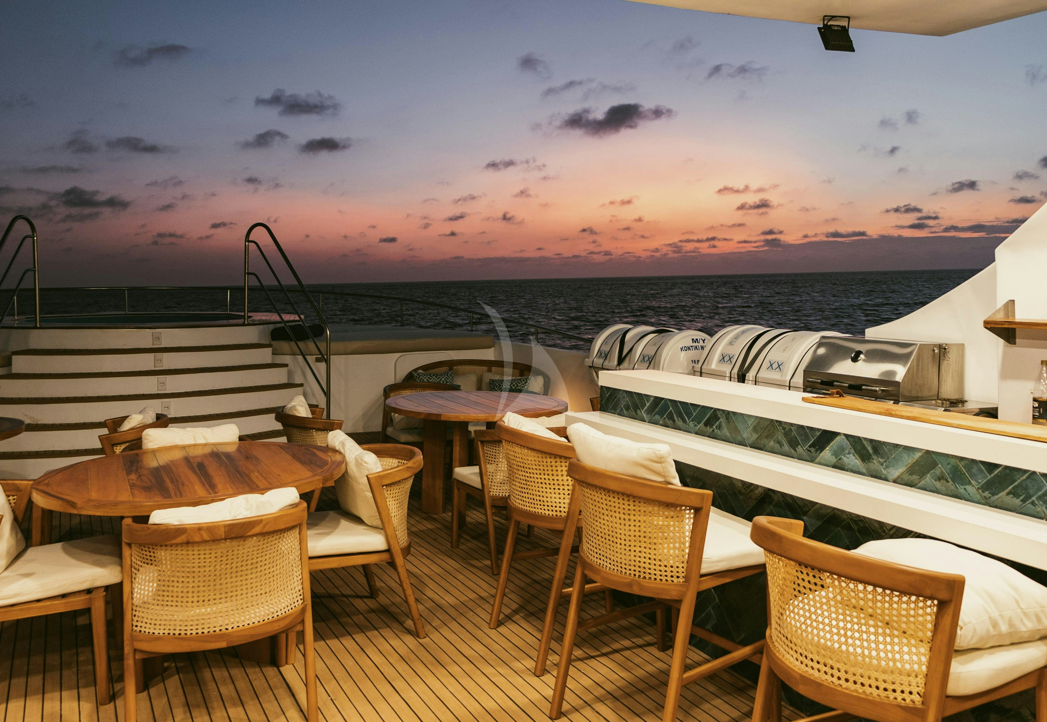 a deck with chairs and tables on it aboard KONTIKI WAYRA Yacht for Charter