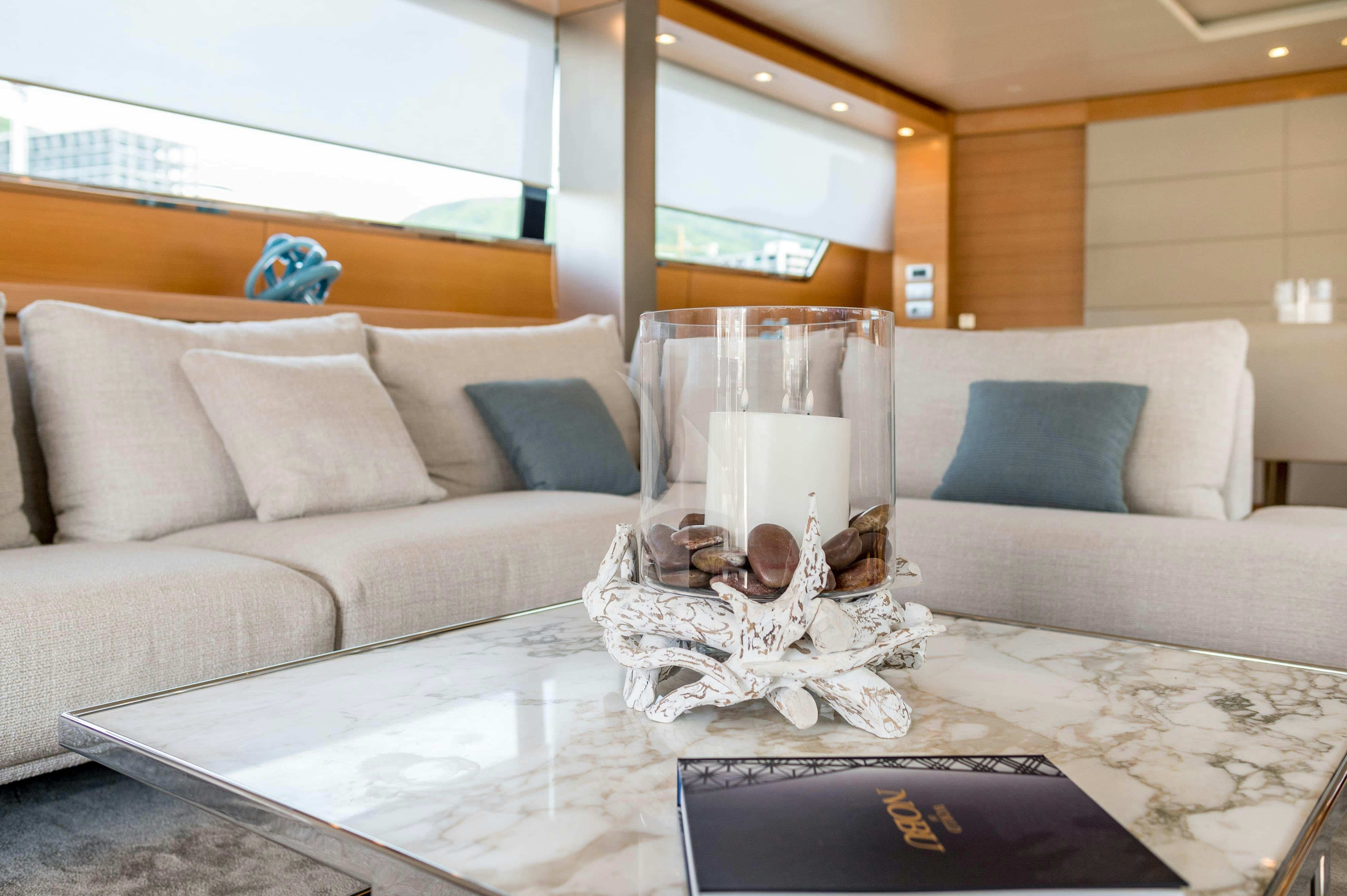 a white couch with a glass of milk on it aboard PERTULA Yacht for Charter