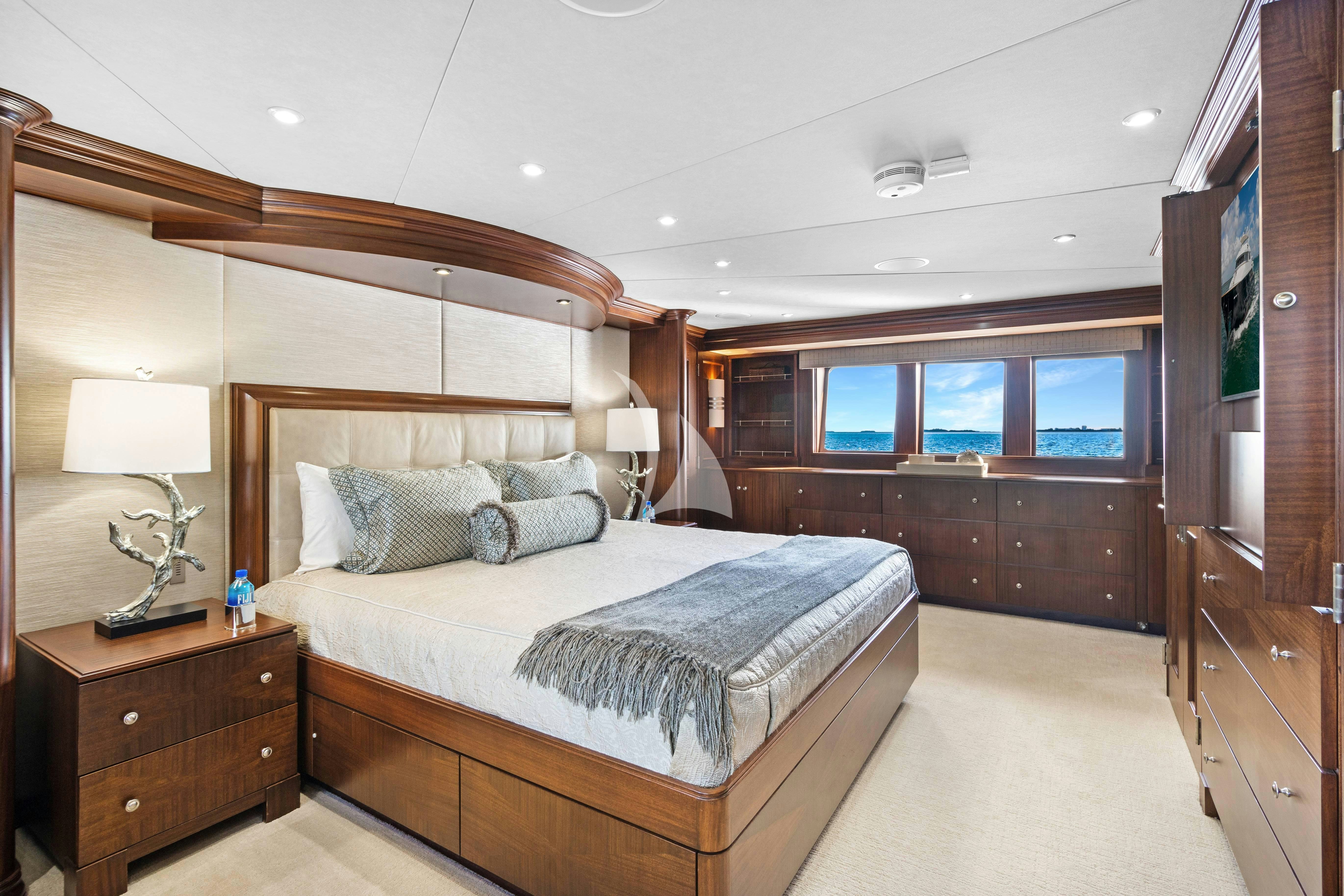 a bedroom with a bed and a dresser aboard GITANA Yacht for Charter