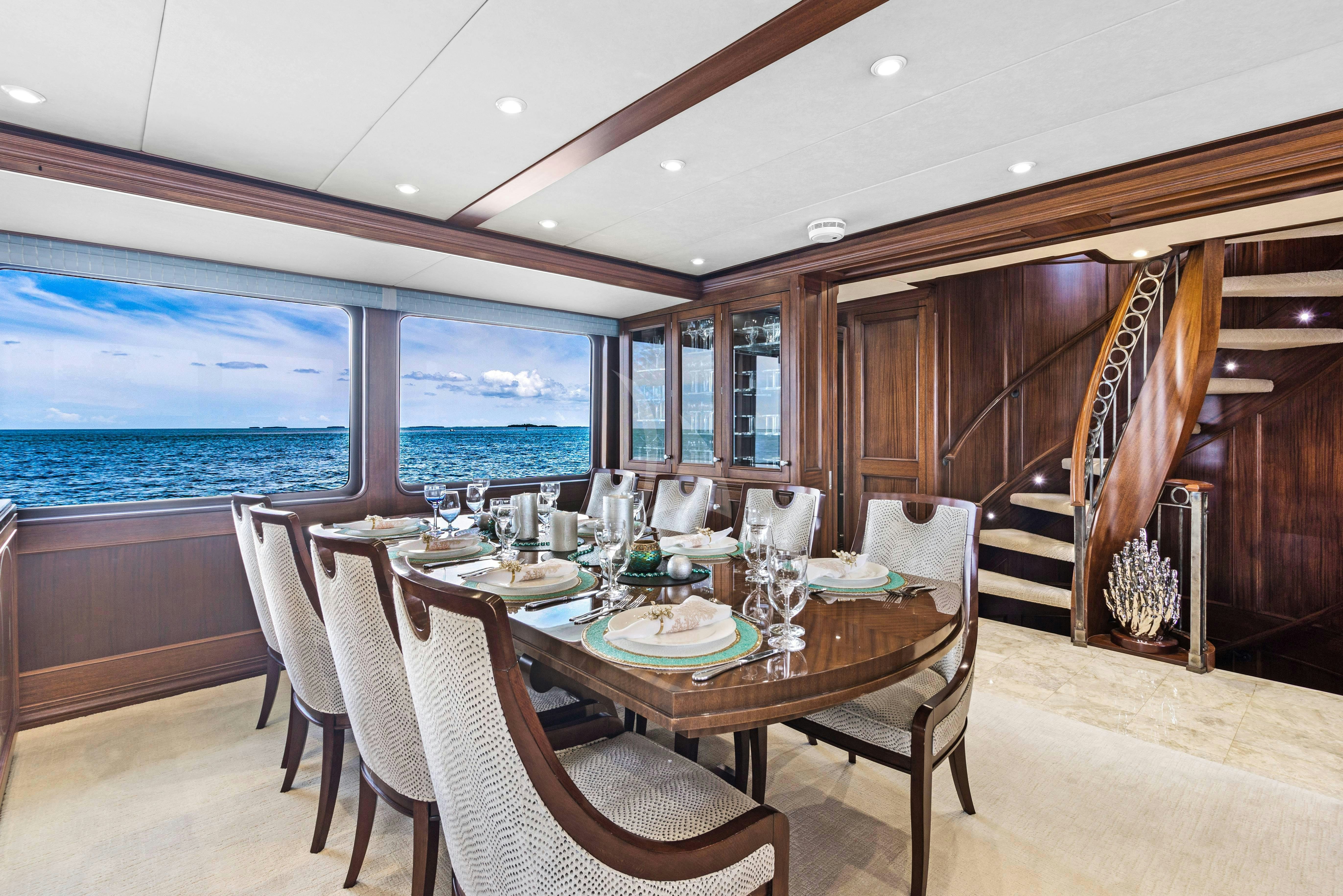 a dining table and chairs in a room with a view of the ocean aboard GITANA Yacht for Charter