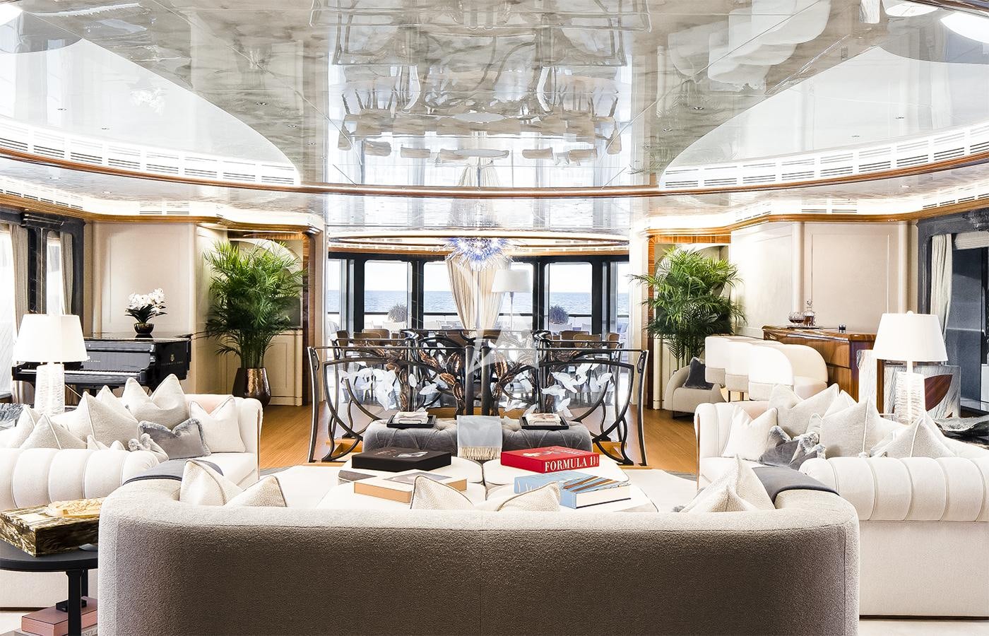 a living room with a large white couch and a large window aboard AHPO Yacht for Charter