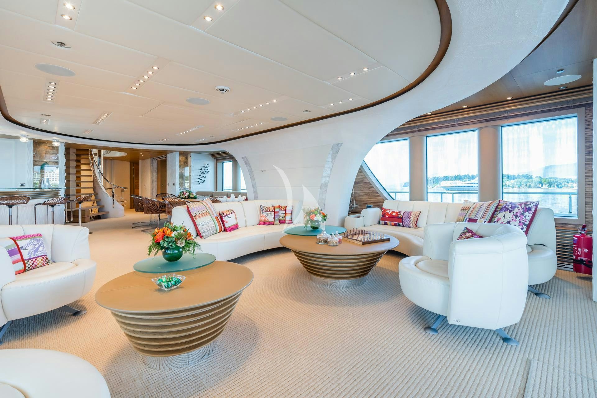 a living room with a large white couch and a large window aboard SERENITY Yacht for Charter