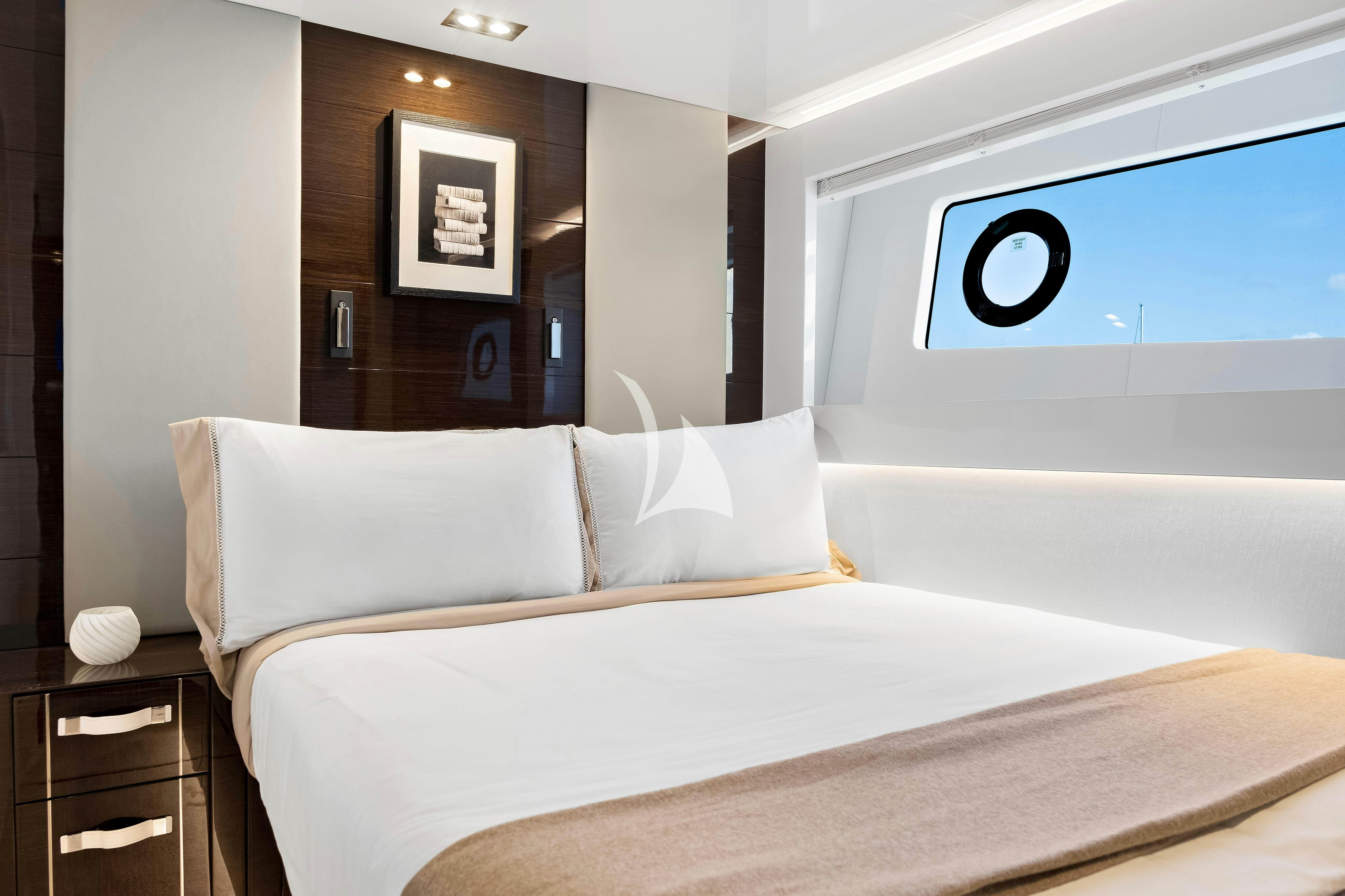 a bed with a white comforter aboard OMNIA Yacht for Charter