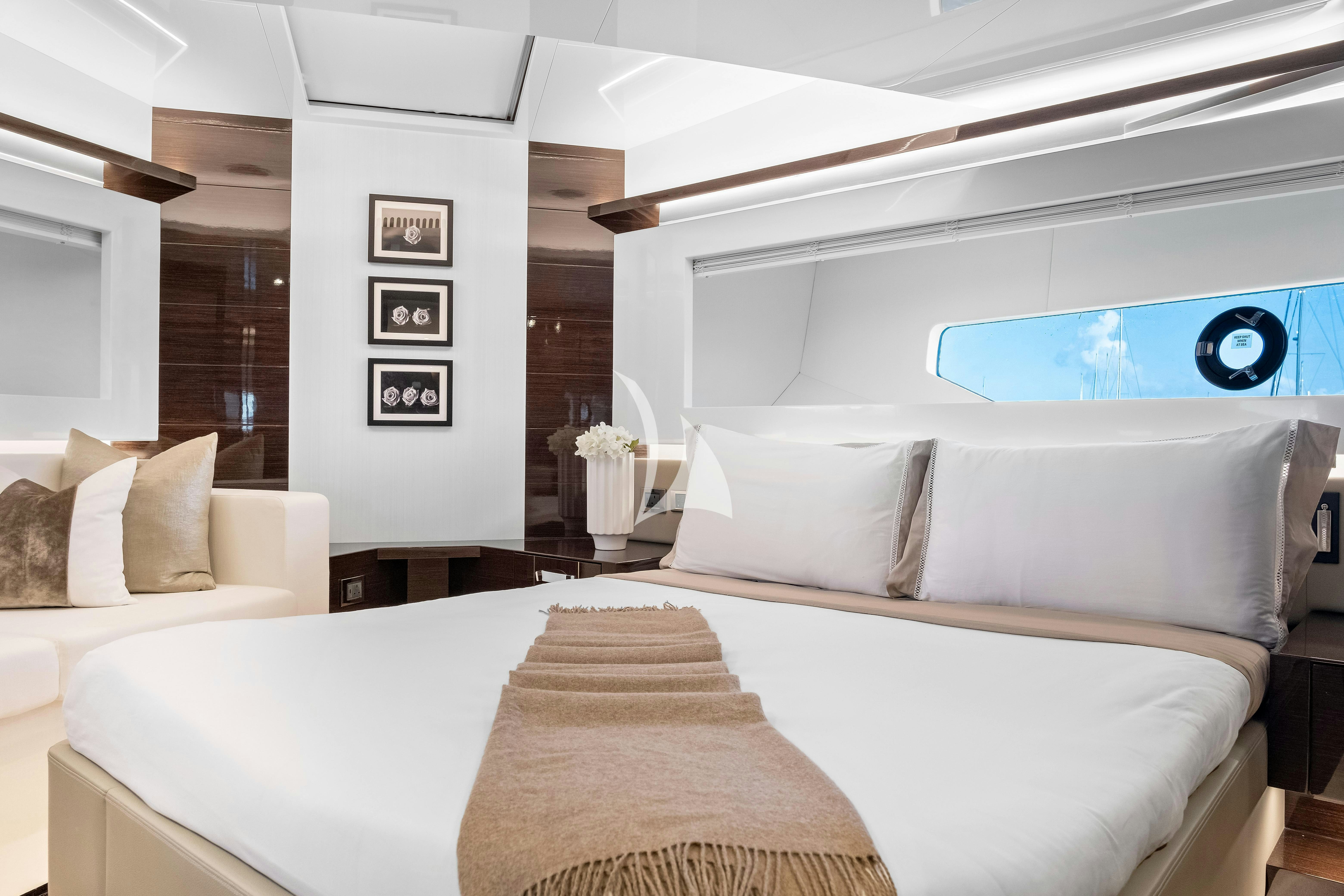 a bed with a white bed spread aboard OMNIA Yacht for Charter