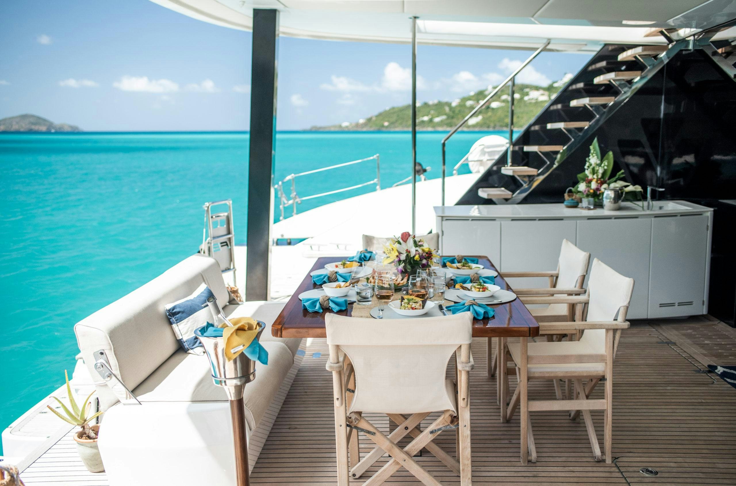 a table and chairs on a deck overlooking a body of water aboard BUNDALONG Yacht for Charter