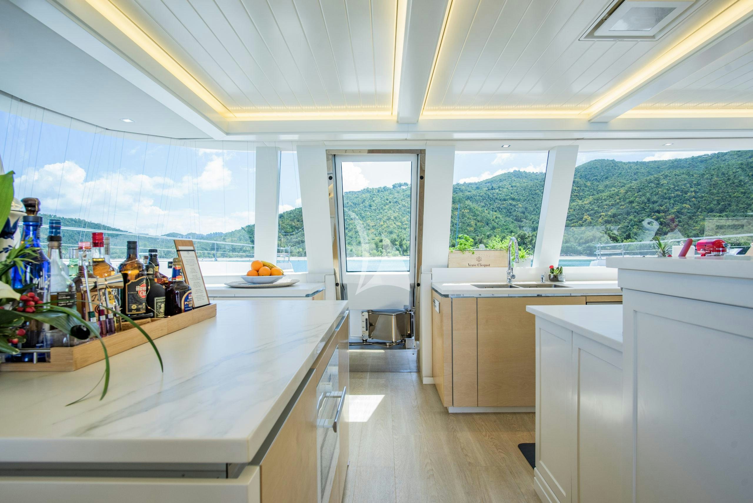 a room with a table and a window with a view of a city aboard BUNDALONG Yacht for Charter