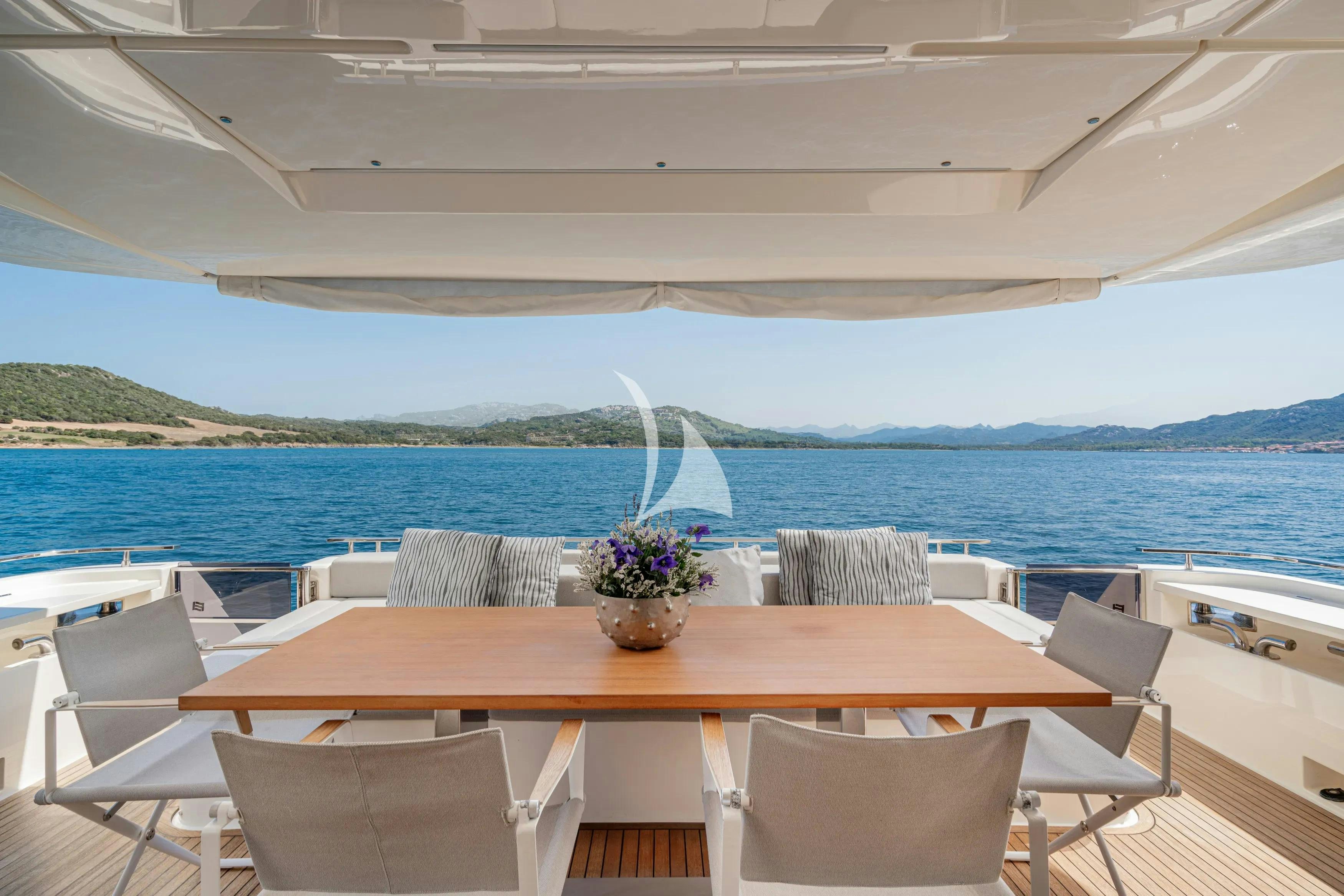 a table with chairs on it next to a body of water aboard E3 Yacht for Charter