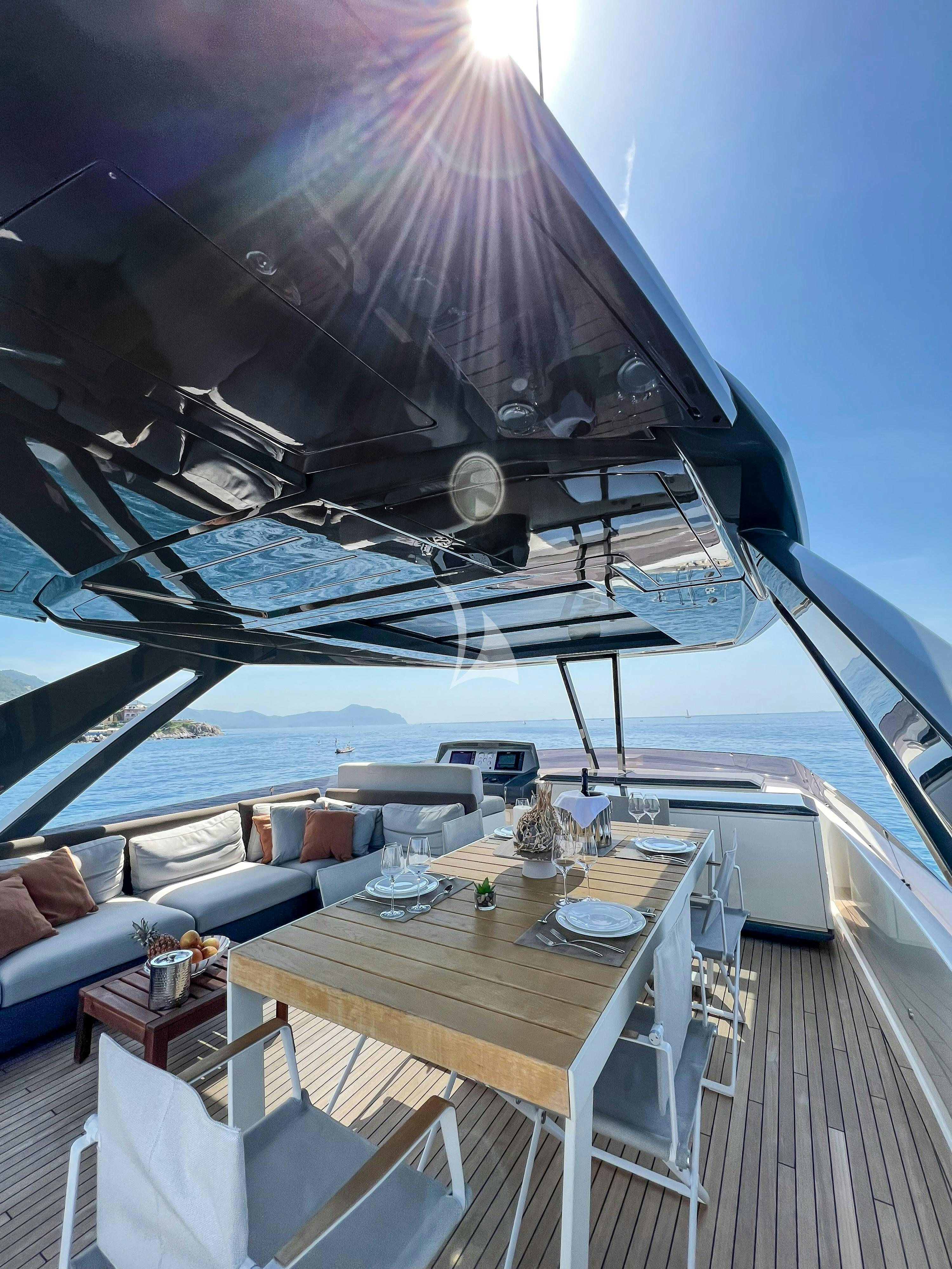 a deck with a table and chairs on it aboard E3 Yacht for Charter
