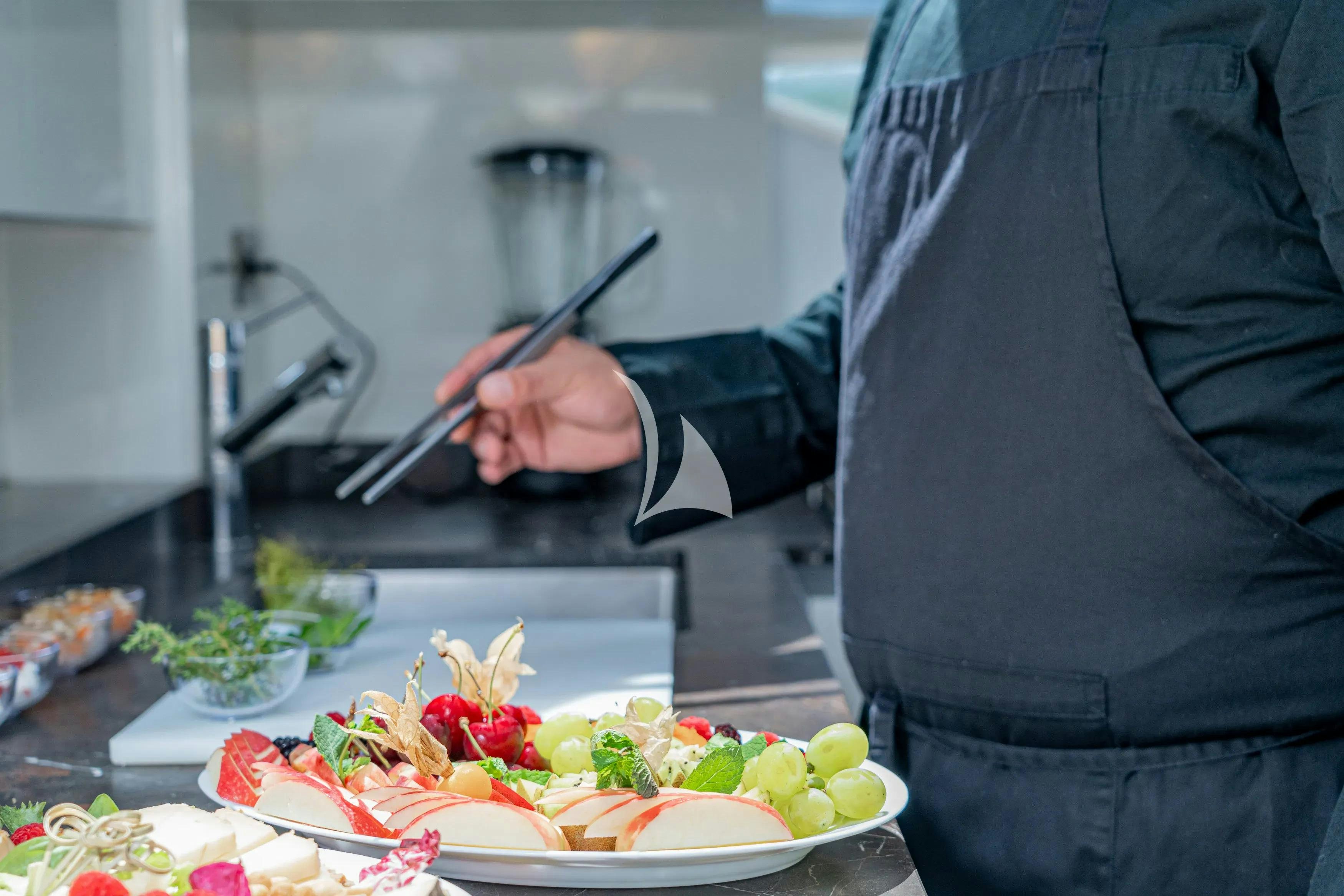 a person cutting a cake aboard E3 Yacht for Charter