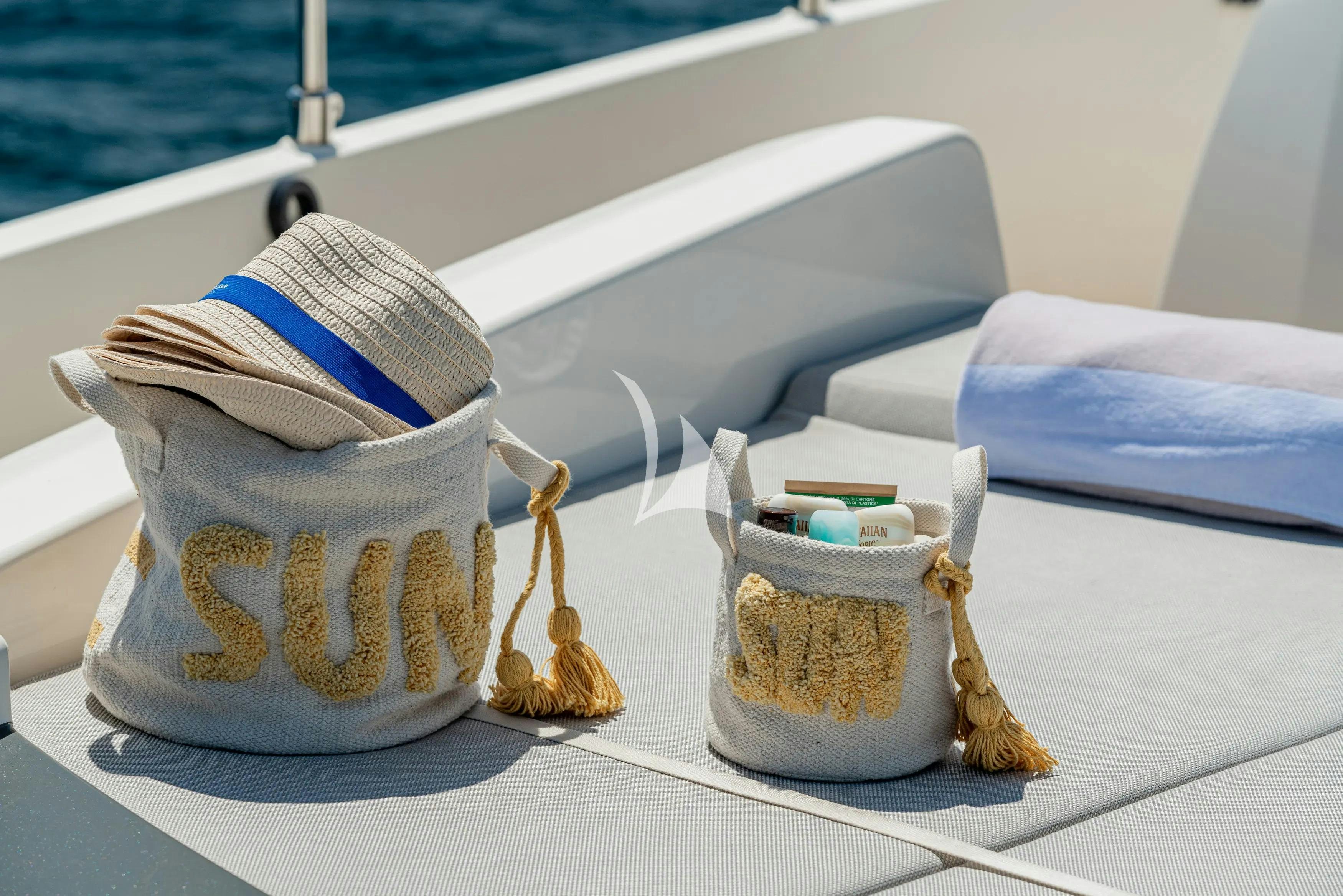 a pair of sunglasses with a hat and a purse on a boat aboard E3 Yacht for Charter