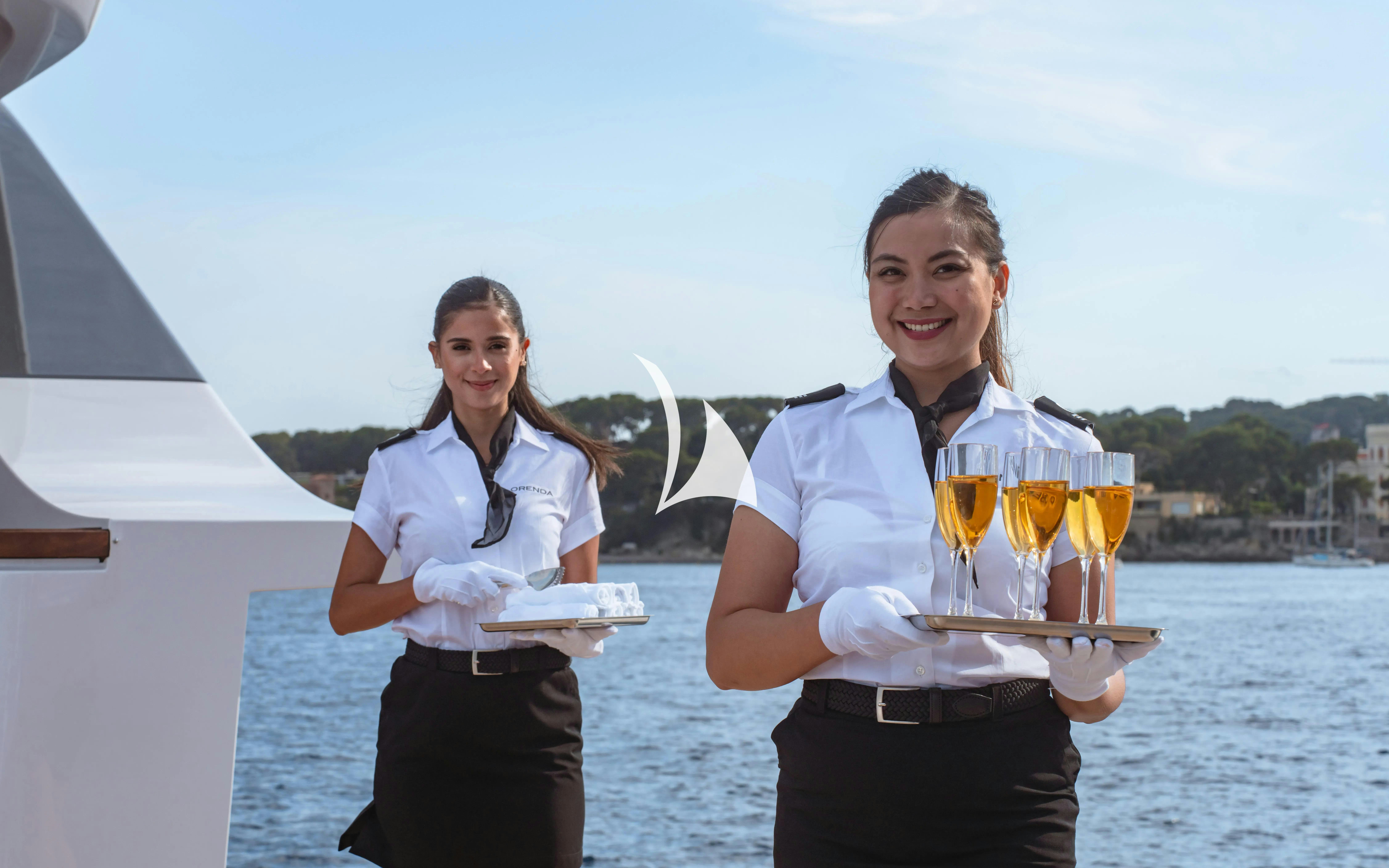 a man and woman holding a tray of food aboard WAVE Yacht for Charter