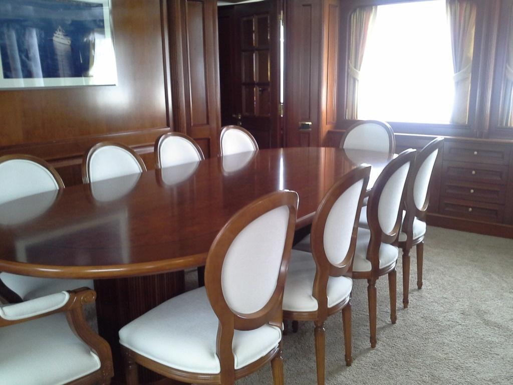 a room with a table chairs and a window aboard INOUIS Yacht for Charter