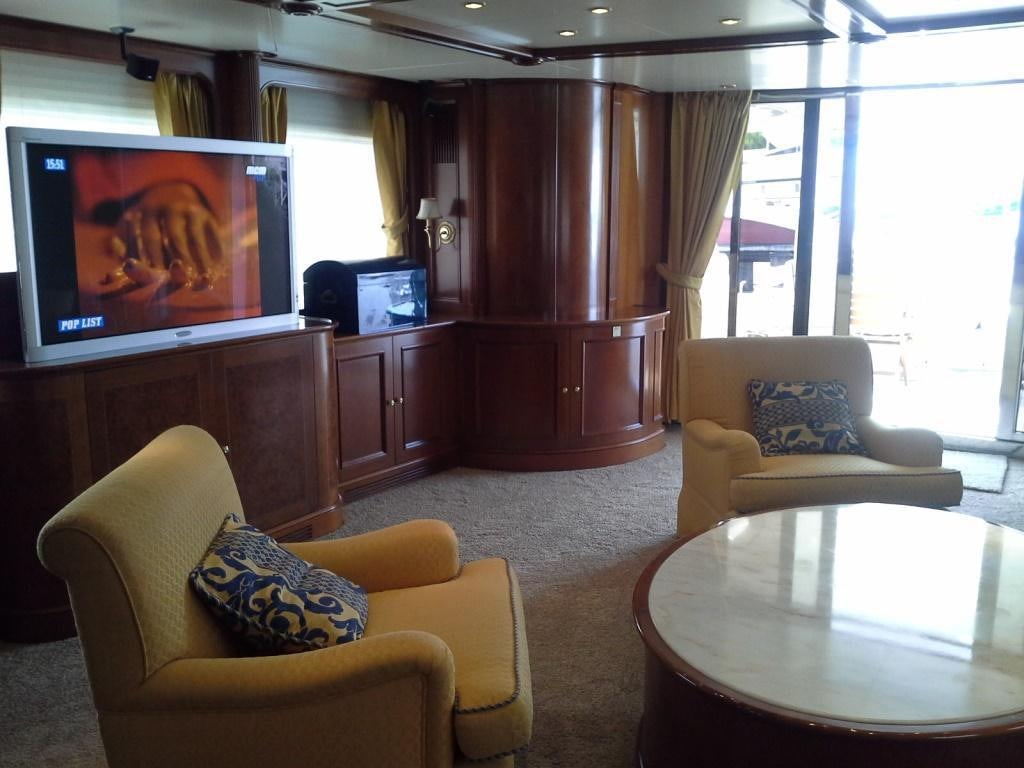 a living room with a tv and furniture aboard INOUIS Yacht for Charter