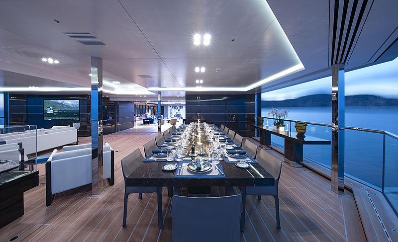 a large room with a table and chairs and a large window aboard BOLD Yacht for Sale