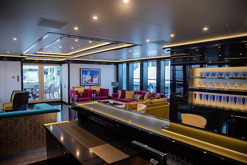 a large room with a piano and a large window aboard LADY VERA Yacht for Charter