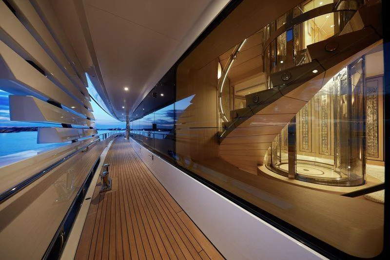 a long hallway with a metal railing aboard JOY Yacht for Charter