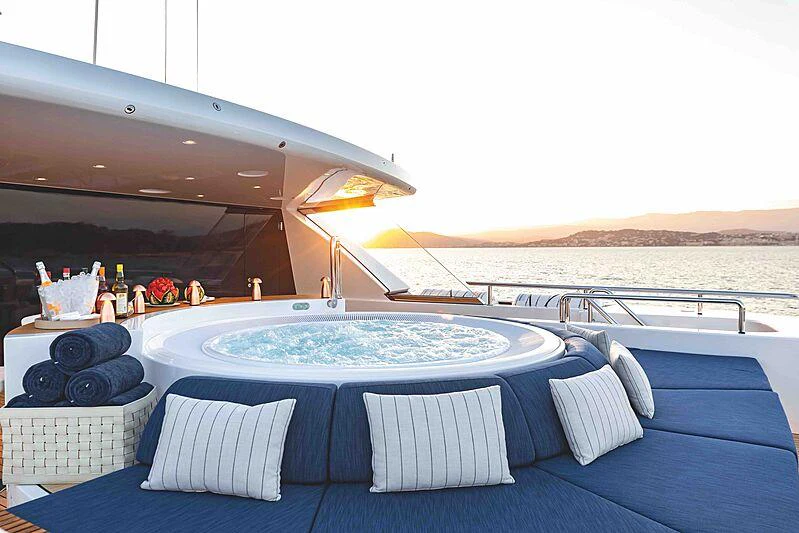 a large pool with a table and chairs on the deck aboard SOARING Yacht for Charter
