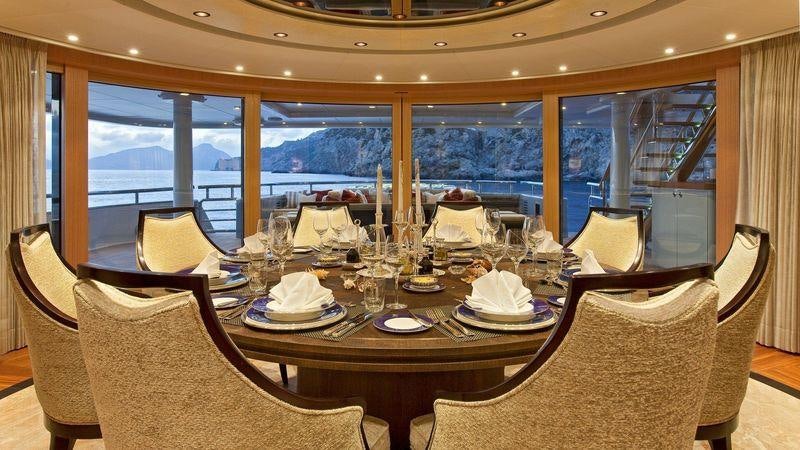 a dining table with chairs and a large window aboard VENTUM MARIS Yacht for Charter