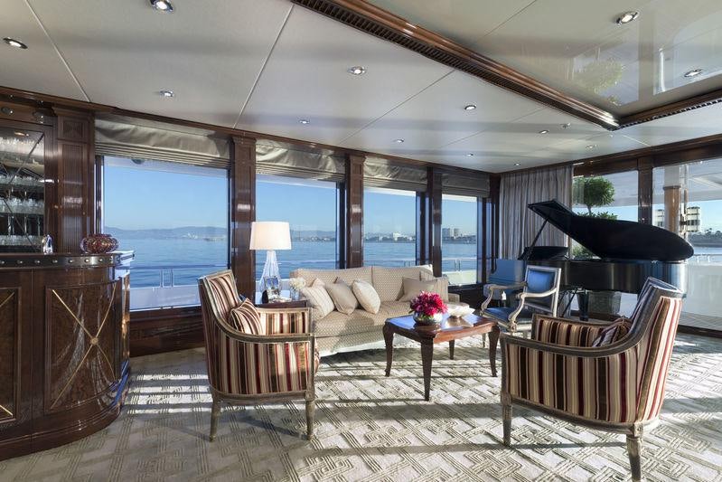a living room with a large black piano and a large window aboard INVICTUS Yacht for Charter