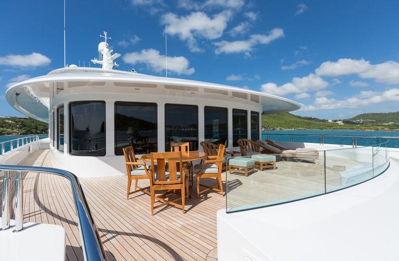 a deck with chairs and tables on it by the water aboard INVICTUS Yacht for Charter