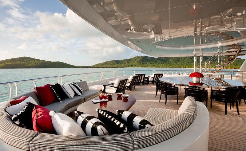 a large living room with a large deck overlooking a lake aboard INVICTUS Yacht for Charter