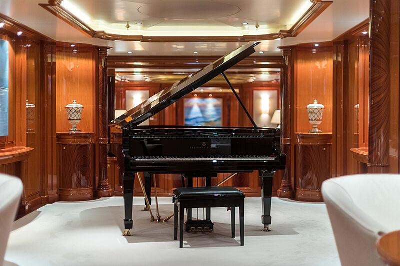 a piano in a room aboard JOIA THE CROWN JEWEL Yacht for Charter