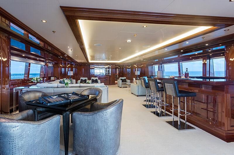 a large room with a table and chairs aboard JOIA THE CROWN JEWEL Yacht for Charter