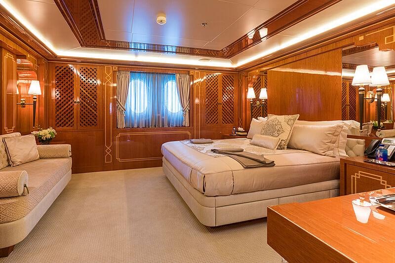 a large room with a bed and a large window aboard JOIA THE CROWN JEWEL Yacht for Charter