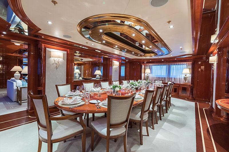 a large dining room with a large chandelier aboard JOIA THE CROWN JEWEL Yacht for Charter