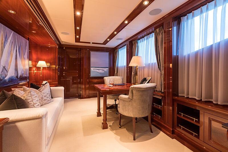 a living room with a table and couches aboard JOIA THE CROWN JEWEL Yacht for Charter