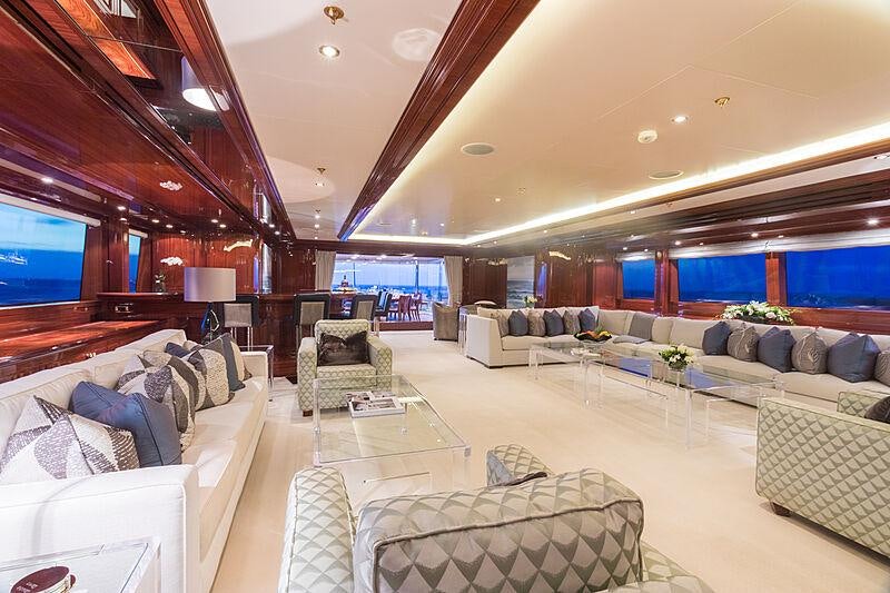 a living room with a large sofa aboard JOIA THE CROWN JEWEL Yacht for Charter