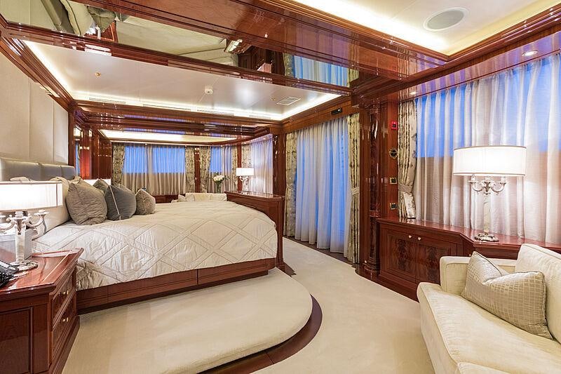 a bedroom with a bed and a window aboard JOIA THE CROWN JEWEL Yacht for Charter