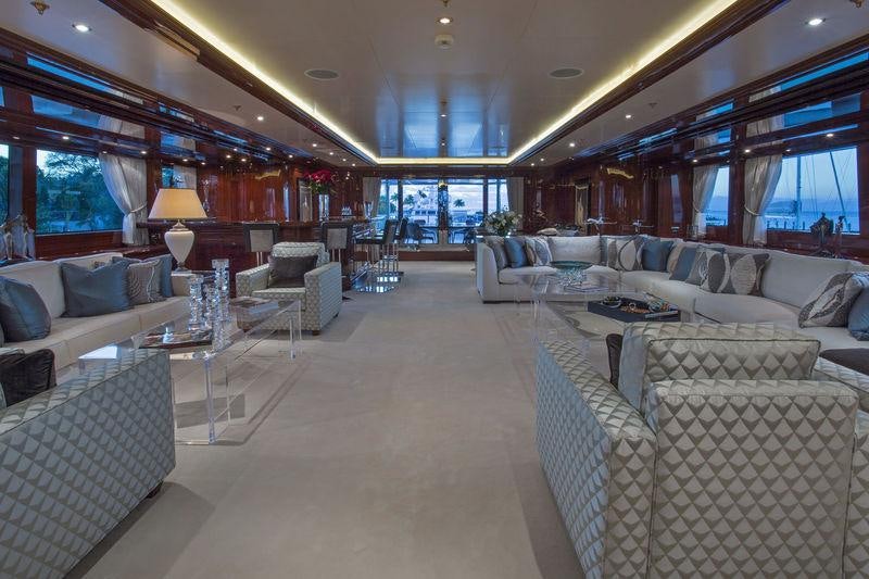 a large living room with white furniture aboard JOIA THE CROWN JEWEL Yacht for Charter