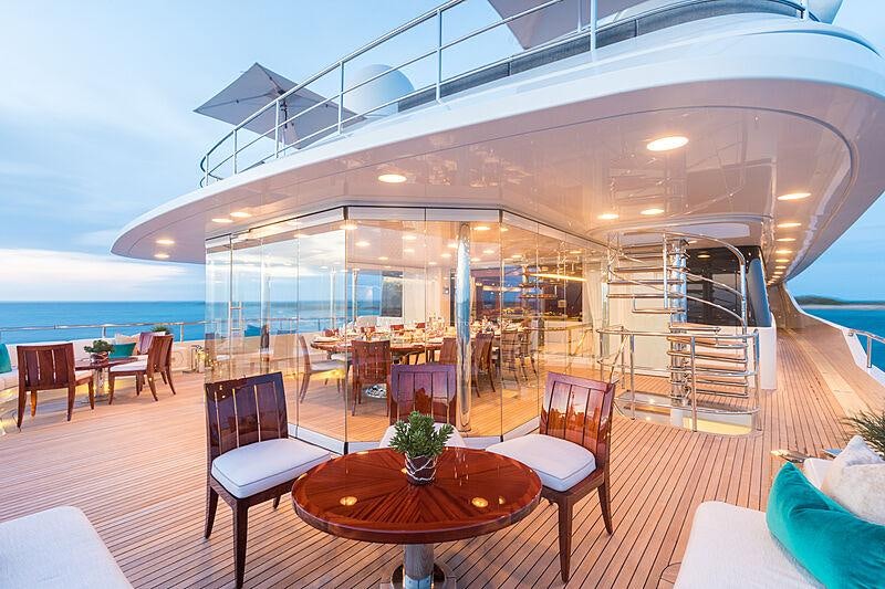 a large room with tables and chairs aboard JOIA THE CROWN JEWEL Yacht for Charter