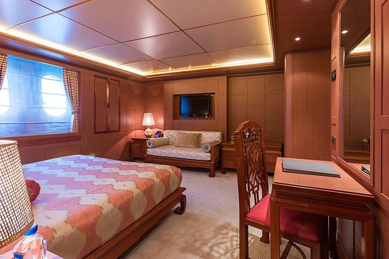 a bedroom with a bed and desk aboard JOIA THE CROWN JEWEL Yacht for Charter