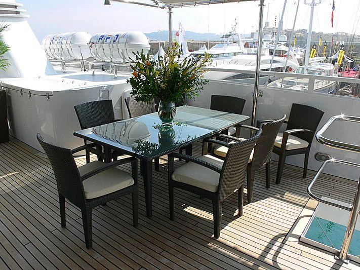 a table and chairs on a deck aboard MAGNA GRECIA Yacht for Charter