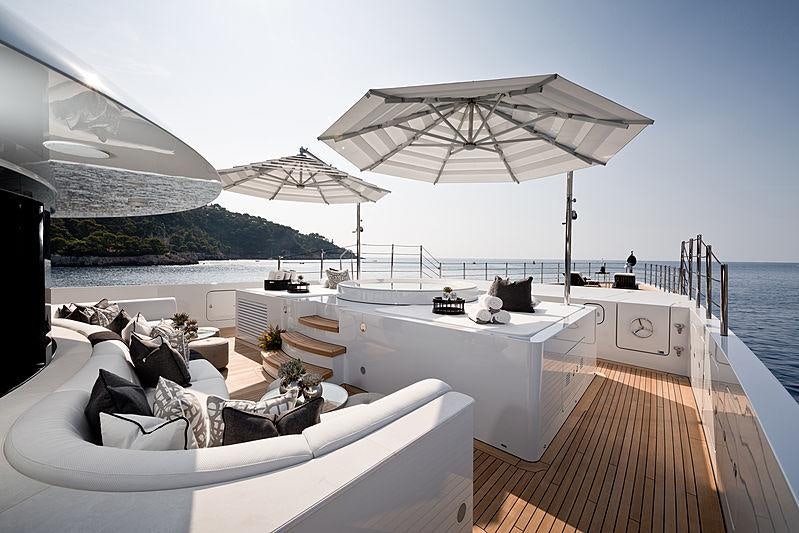 a large white lounge chair on a deck overlooking a body of water aboard SOUNDWAVE Yacht for Charter