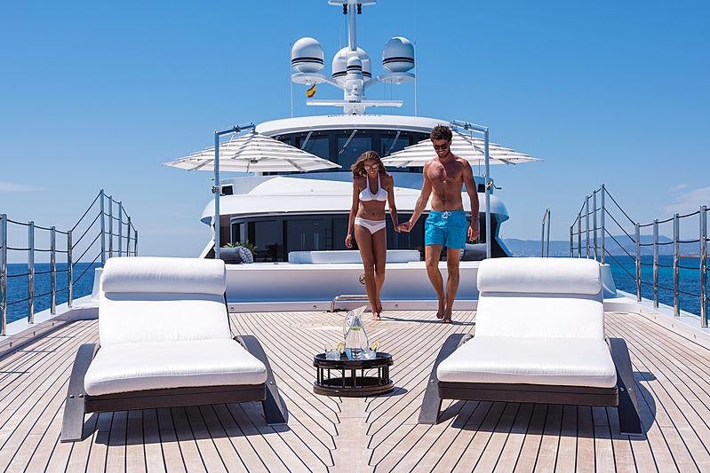 a couple of people standing on a boat with a statue in the background aboard SOUNDWAVE Yacht for Charter