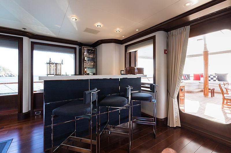 a large kitchen with a bar and chairs aboard FLAG Yacht for Charter
