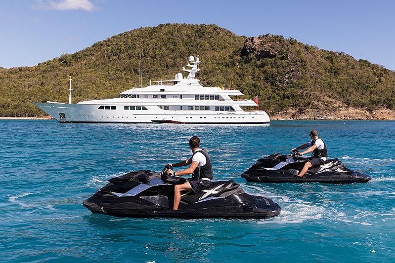 a group of people on a boat in the water with a boat in the background aboard FLAG Yacht for Charter