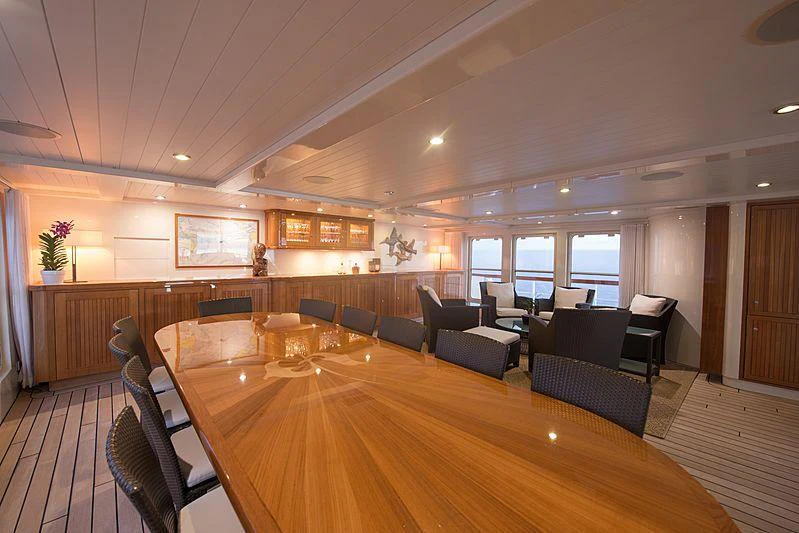 a large room with a wood floor and a large wood table with chairs aboard SEAWOLF Yacht for Charter