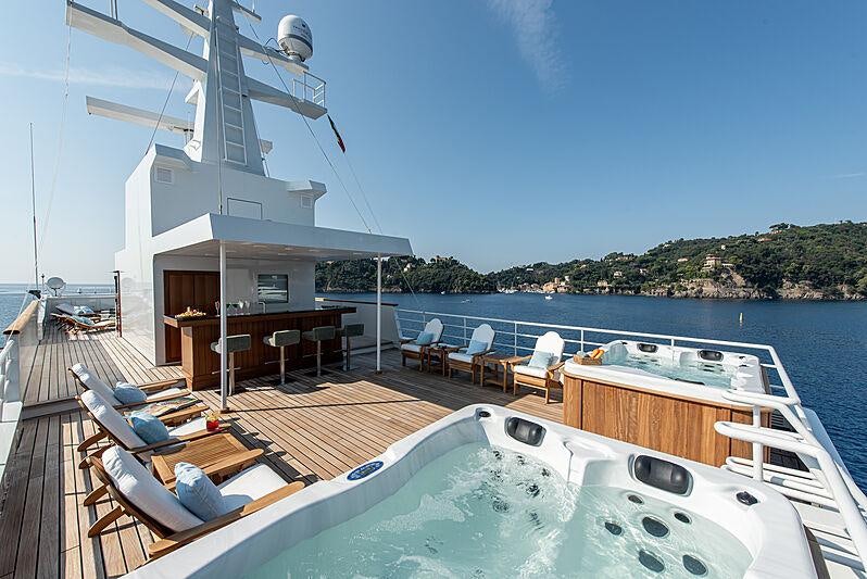 a deck with a pool and a deck with chairs and a deck aboard BLEU DE NIMES Yacht for Charter
