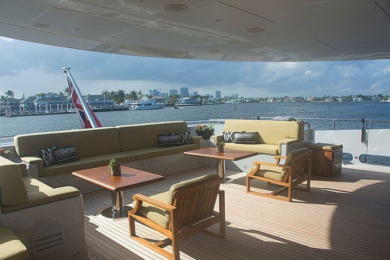 a room with a table chairs and a view of a city aboard SOUTH Yacht for Charter