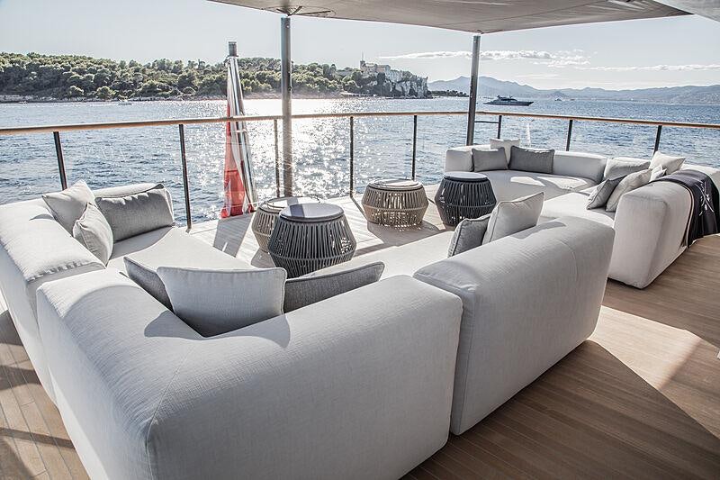 a large white couch with a large window overlooking a body of water aboard SEVERIN*S Yacht for Charter