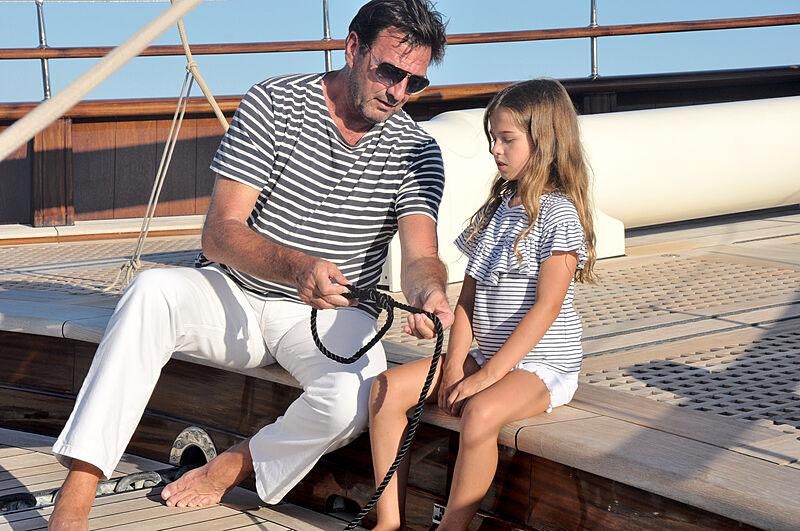 a man and a woman sitting on a dock aboard MIKHAIL S. VORONTSOV Yacht for Charter