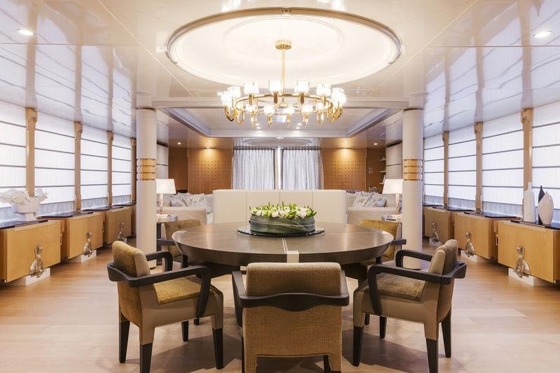 a room with a table chairs and a chandelier aboard AMORE MIO 2 Yacht for Sale