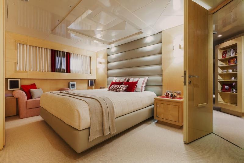 a bedroom with a bed and a bookcase aboard AMORE MIO 2 Yacht for Sale