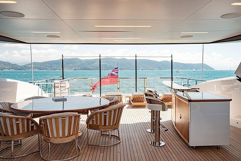 a table and chairs on a deck overlooking a body of water aboard LADY LENA Yacht for Charter