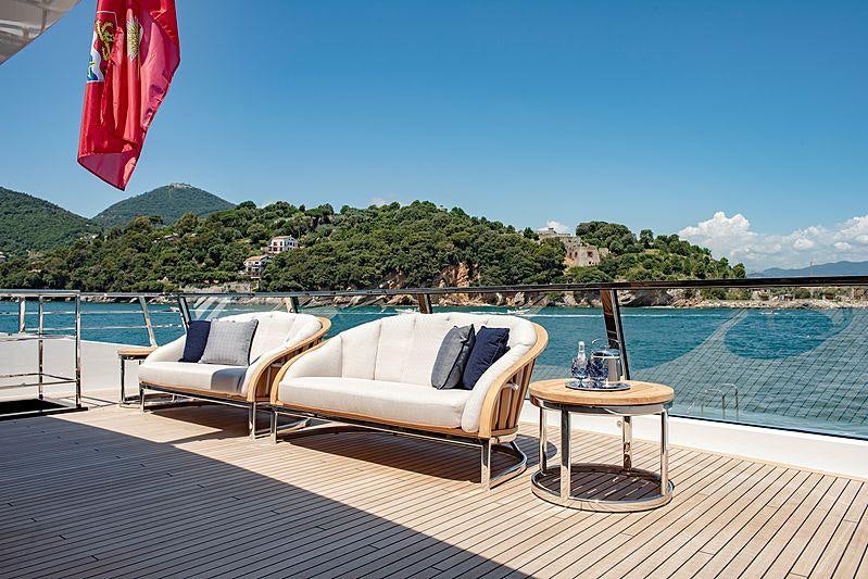 a couple of white couches on a deck overlooking a body of water aboard LADY LENA Yacht for Charter